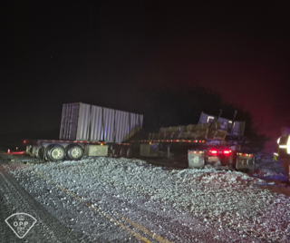 Semi-truck trailer overturned on gravel road