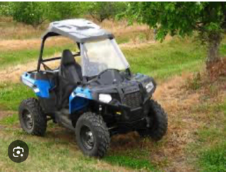 Blue and black utility vehicle on grass.