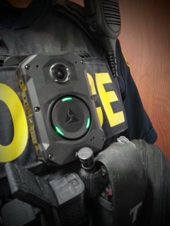 Tactical vest with green-lit camera.