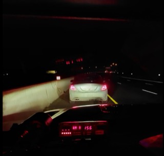 Car on highway at night, brake lights illuminated