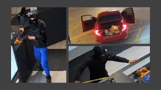 Person in dark clothing and face covering standing near a car with open trunk. Red car with open trunk. Person in dark clothing and face covering reaching toward the ground.