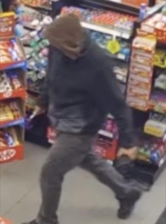 Person walking past a store shelf with snacks