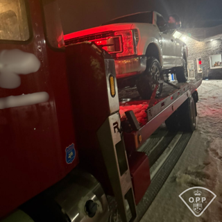 Tow truck with a pickup truck on the flatbed.