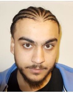 Man with dark hair and beard, looking directly at the camera