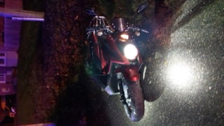 Red motorcycle headlight illuminates the scene