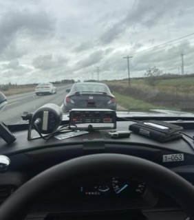 Dashboard with emergency vehicle equipment, cars on the road, overcast sky