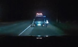 Police car with flashing lights on a dark road