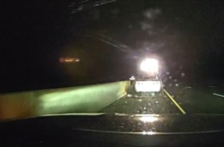 Emergency vehicle headlights illuminating a wet road.