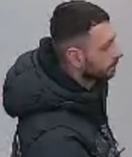 Man in a black hooded jacket, profile view