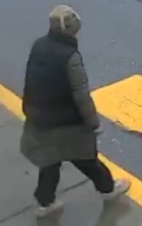 Person walking, wearing a dark coat and pants