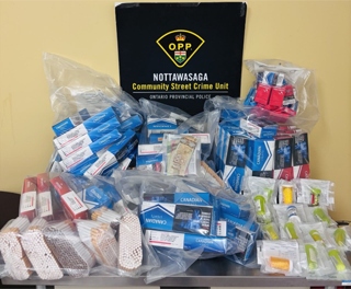 Seized cigarettes and pills in plastic bags. NOTTAWAGA Community Street Crime Unit. ONTARIO Provincial Police.