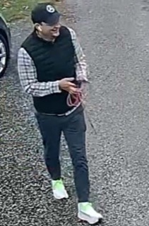 Person wearing a black vest, plaid shirt, and black pants.