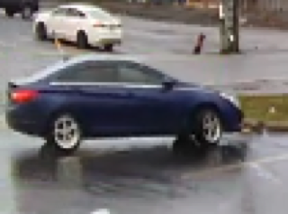 Dark blue sedan parked on a wet street