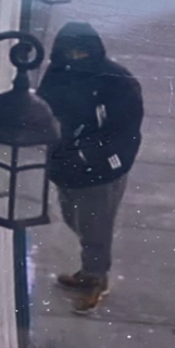 Person wearing a hooded sweatshirt and dark pants.