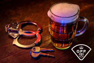 Handcuffs and keys next to a pint of beer