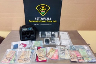 Stacks of Canadian and Euro banknotes on a table, money counter nearby.