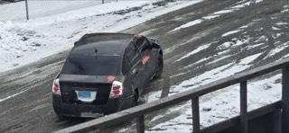 Black sedan on a snow-covered hill
