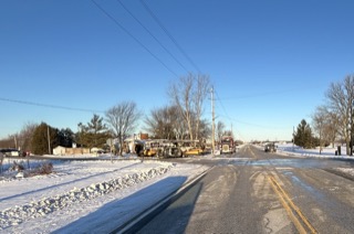 Snow-covered road with utility trucks.