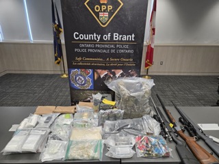 Seized drugs and firearms in evidence bags.