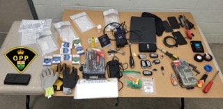 Pile of documents, tools, and electronics on a surface.