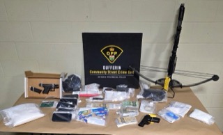 Bow and arrow on a table with packages of drugs and cash.