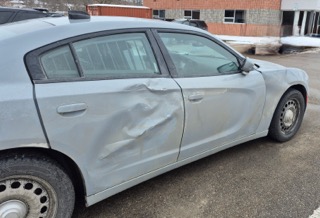 Damaged gray sedan with a dented door