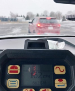 Dashboard view, red car ahead, snowy road