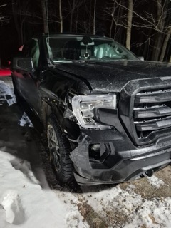 Damaged black pickup truck in snow