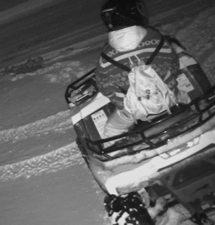 Person on a snowmobile, black and white