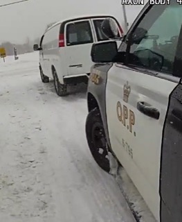 Police van with visible branding and license plate in snow.