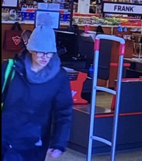 Person wearing a gray knit hat and dark jacket.