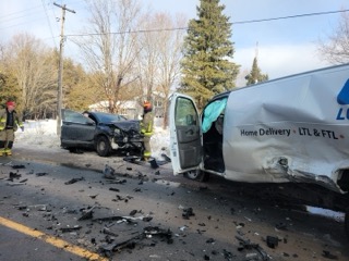 Delivery van and car collided, debris scattered on the road