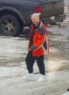 Person wearing a red and white jacket, black pants, and a white beanie.