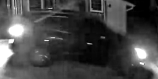 Dark vehicle moving forward, headlights bright.